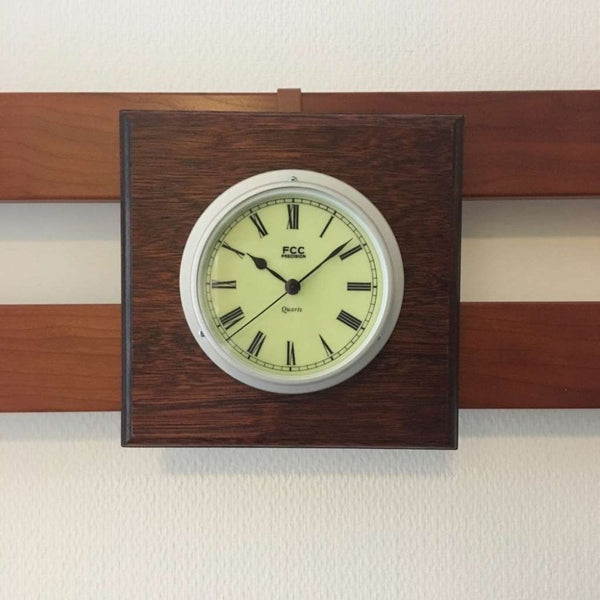 Finnies The Jewellers Aluminum Clock with Luminous Green Dial on Wooden Wall